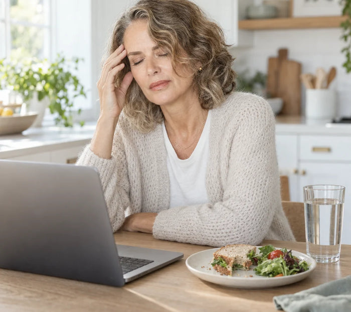 Tired woman at her laptop holding her head