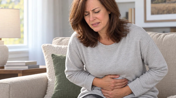 Woman on the sofa holding her stomach